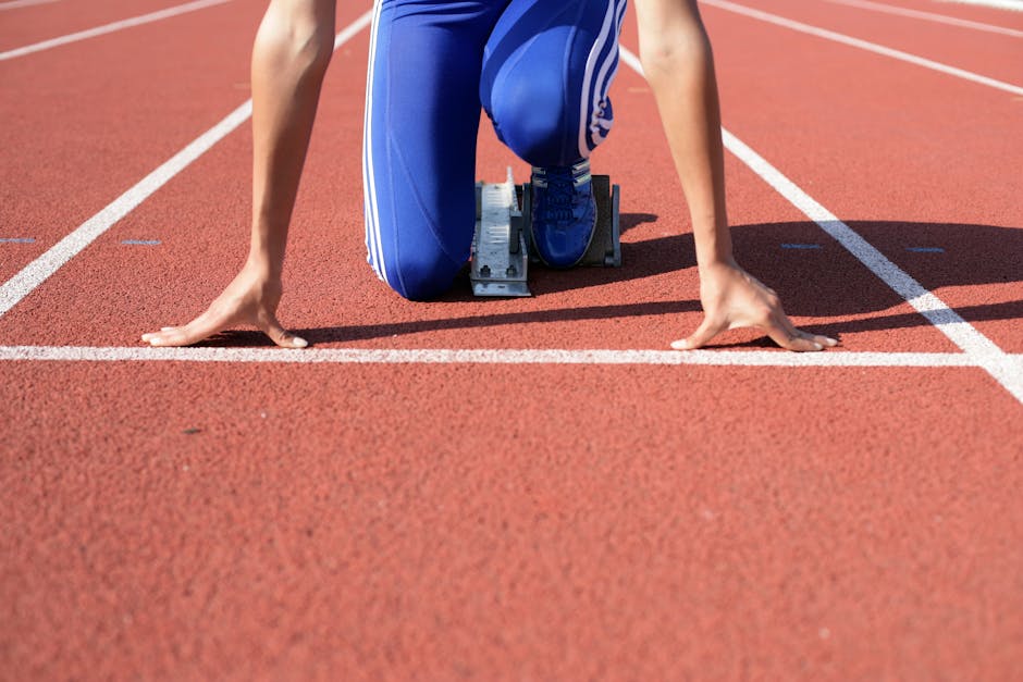 Atleta em posição de largada na pista de corrida